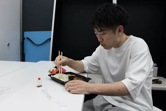 スタッフ用の余ったハンバーグ弁当を食べる拳四朗。試合後は盛大な祝勝会に参加するのが常だったが、この日の夕食はこれで終わりだった