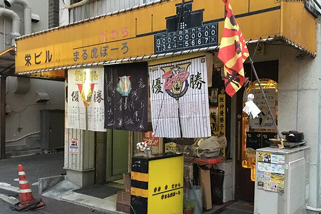 「まる虎ぽーろ」の外観。最盛期には阪神の関連ニュースに合わせて、ドア前の張り紙が頻繁に入れ替わっていた