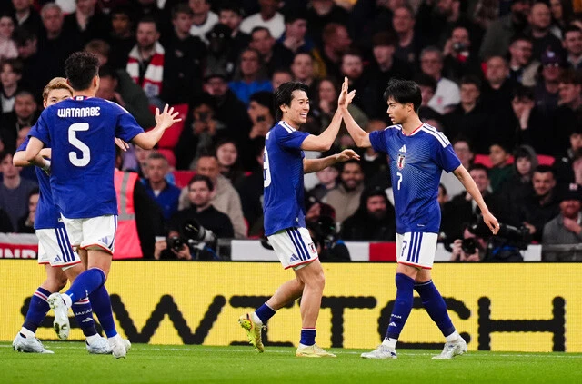 イングランド戦で三笘（右）からのパスを受けて左サイドPAに侵入し、冷静にパスを戻して決勝点をアシストした中村（中央）。ゴール後にふたりはハイタッチを交わした