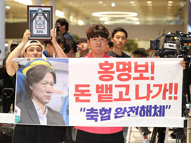 韓国代表の帰国時、ファンが掲げたプラカード。「洪明甫！　金を払って出ていけ!!」などと書かれている