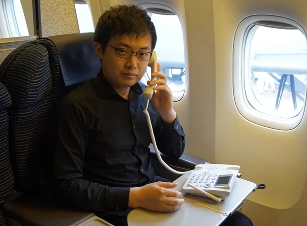 航空機内でフライトモードをテストする木野社長。機内へ固定電話を持ち込むことで“できる男”感が大幅UP!