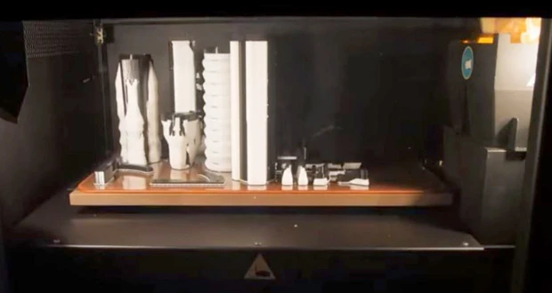 写真は3Dプリンターでパーツを出力している状態。40mm口径のグレネード弾を発射する銃身やグリップ部分などは、樹脂パーツで制作されている