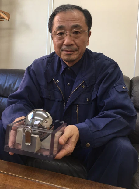 シリコン単結晶球体の見本を持つ岡本社長