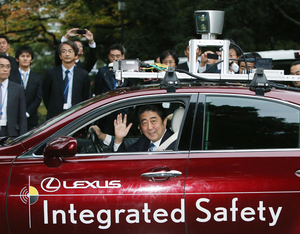 2013年11月、国会周辺の公道で自動運転車に試乗した安倍首相。これをきっかけに道交法の運用が大幅に変更され、公道での実験が積極的に容認された。