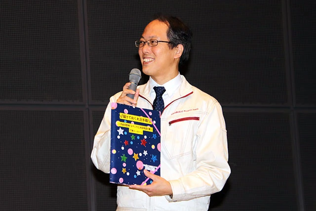 応援メッセージが詰まったメッセージブックを手にうれしそうにする津田氏