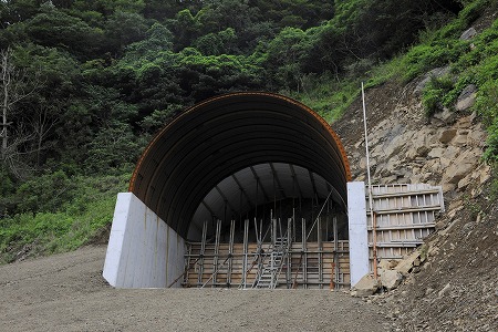 対馬・厳原市阿連の北で「日韓 トンネル」の工事は進行中。山の斜面にトンネル の入り口が開く